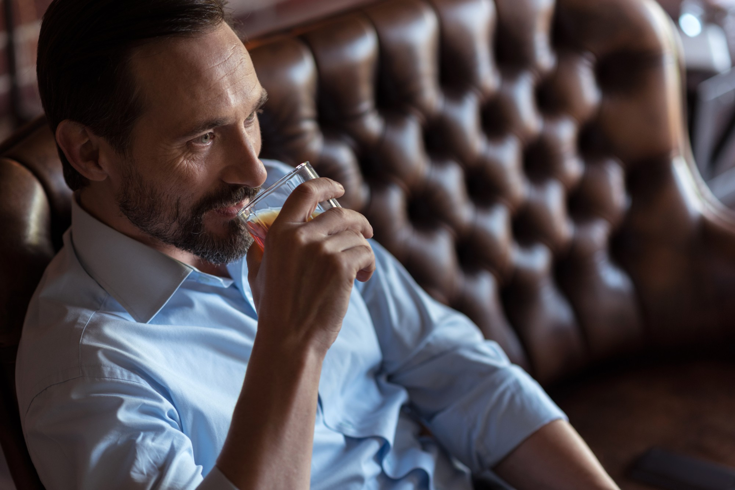 Mature man enjoying a drink in a Brisbane-style lounge